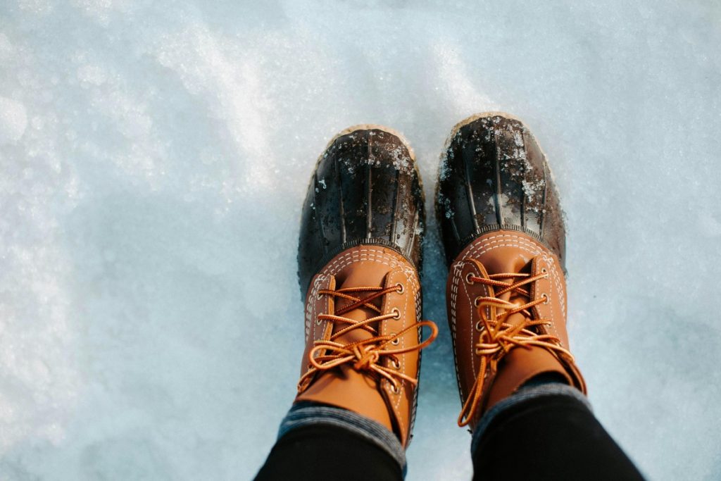 Close-up of winter boots standing on fresh snow. Ideal for cold weather outdoor themes.