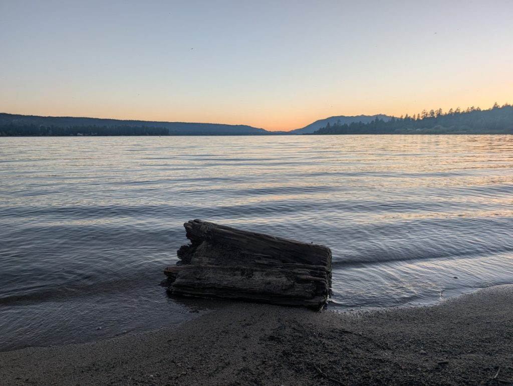 big bear lake california sunset over the lake with a short log in the foreground
