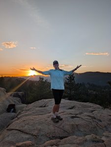 big bear hiking adventures guide standing on rock overlook with sunset in background