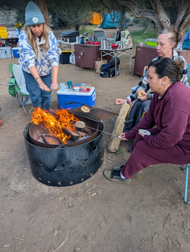 women sitting around a campfire women's gathering