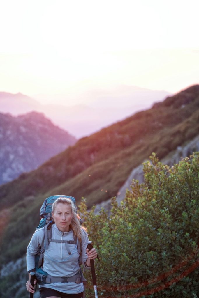 hiker going uphill with mountain view behind her big bear trail etiquette